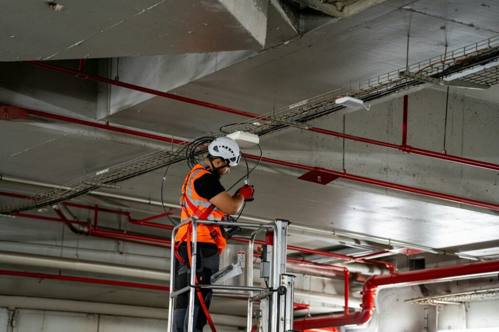 Construction worker on lift installing ceiling components